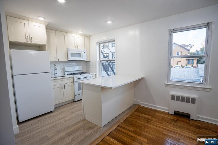 Welcome to a beautifully renovated condo apartment on the second floor that blends modern upgrades with timeless charm. Step into a bright, open-concept living space featuring fresh paint, gleaming hardwood floors, and a brand-new breakfast bar perfect for casual dining or entertaining. The kitchen has been completely remodeled, showcasing premium fixtures, faucets, cabinets, subway-tile backsplash, new Whirlpool refrigerator, modern gas stove, and built-in microwave. Thebathroom features elegant marble-look tile and a luxurious standing shower with matte-black finishes. Located on a quiet tree-lined street just moments from Main Street shops, dining, and NYC transportation, this home offers the perfect mix of style, comfort, and convenience. Highlights: Recently renovated kitchen with premium finishes New refrigerator and modern appliances Freshly painted throughout Polished hardwood floors Brand-new breakfast bar Stunning bathroom with walk-in shower Close to bus lines, parks, and schools Optional garage parking available for $150/month.