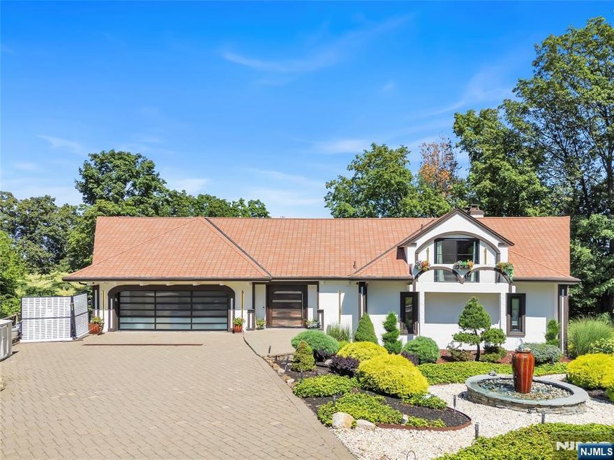 STUNNING SPANISH VILLA-STYLE ESTATE MILLION-DOLLAR SKYLINE VIEWS PRIVATE OASIS SPA RETREAT at the end of a private cul-de-sac, this fully renovated Spanish villa-style showpiece offers breathtaking skyline panoramas and million-dollar views from nearly every room. Nestled on beautifully tiered, exotically landscaped grounds with architectural lighting, it perfectly blends privacy with Mediterranean elegance.Step inside through a handcrafted pivoting front door into a grand living space featuring high, soaring wood-beamed ceilings, one of three dramatic stone fireplaces, and a flowing open floor plan. Entertain in the formal dining area and gourmet chef's kitchen with quartz counters, oversized island, pro-grade appliances, and access to three expansive, newly renovated outdoor decks with lighting.The first-floor primary suite is a private retreat with deck access, fireplace, dual walk-in closets, and a spa-inspired bath with soaking tub and Euro shower. Upstairs: a home office with balcony and en-suite guest suite. The showstopping lower level includes a year-round indoor saltwater pool, steam shower, 4 person jacuzzi, dry heat sauna, and a custom walnut waterfall bar with cast-iron accents overlooking the skyline. Topped with a custom re-designed red Spanish terra-cotta roof, state-of-the-art garage w/frosted glass doors, full-house generator, smart security, and ceiling-height custom patio doors/windows that bathe the home in natural light.