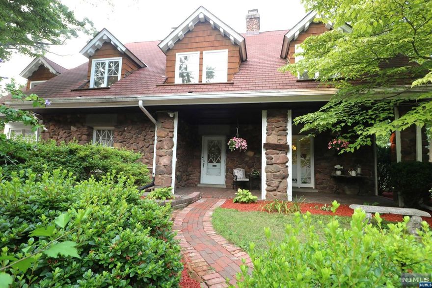 Welcome to one of Nutley's more special homes on a stunningly treelined and quiet street! Full of character and history this home boasts proudly on a stately lot. This center hall colonial is offering hardwood floors throughout, wainscotting, 3 fireplaces, porches, an eat in kitchen, stainless steel appliances, formal dining room, mudroom, window seat, walk in closets, laundry on the second floor, primary bedroom with ensuite and private sunroom overlooking a beautiful yard with in ground pool & patio. The grand and formal living room includes built in bookshelves, a fireplace, and charming leaded glass French doors to a bright sunroom which opens to the perfect yard for entertaining. Plenty of parking leading to a 2 car garage with a loft. This home is said to have been built as a guest house to Jacqueline Kennedy's grandfathers house a block over.