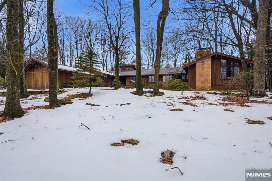 Expansive mid-century inspired ranch on nearly one acre in the sought-after Puddingstone neighborhood, renovated in 2022. The home features a flexible layout with a separate wing offering a private entrance, full kitchen, full bath, bedroom, family room, & laundry, ideal for guests, extended living, or multi-gen setup. A bonus room w/full closet & windows sits between the two wings, allowing the home to flex between a 4-bed/1-bed or 3-bed/2-bed layout or function as an office. Heated in-ground pool, 2-car attached garage, & a level backyard on nearly an acre complete the picture. Inside, the renovated main living space centers on an open-plan kitchen flowing into the dining area & a dramatic living room w/a floor-to-ceiling brick wood-burning fireplace. Soaring vaulted ceilings w/dark wood beams & a wall of windows overlooking the pool fill the home w/natural light. The main level includes a spacious primary bedroom w/en-suite bath & walk-in closet, two additional bedrooms, dual-sink compartmentalized bath, powder room, mudroom & laundry w/built-in cabinetry. The separate wing features its own brick WB fireplace, cedar plank ceilings w/exposed beams, & basement. Full unfinished basement under the main home w/ high ceilings, ready for a gym, playroom, or workshop. Natural gas w/ 3 independent HVAC systems (2 units replaced in 2020), water heater 4 years old, roof & gutters replaced in 2024. Septic w/public sewer available at the street.