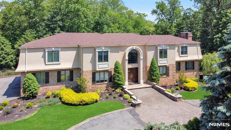 Nestled on a secluded, nature-like property, this spacious & fully fenced home offers exceptional privacy & comfort. A circular driveway welcomes you. A rare first-floor bedroom adds flexibility, while the striking 2-story Great Room with fireplace is wrapped in an upper-level library. Enjoy a fabulous bar/lounge room with fireplace, formal dining room & a stylish eat-in kitchen featuring a large island & premium appliances. Both the kitchen & Great Room offer access to a large deck, perfect for entertaining. Upstairs, the luxurious primary suite boasts a fireplace, dressing room & spa-like bath with dual toilets. Another ensuite bedroom, two additional bedrooms & a hall bath complete the 2nd level. The walk-out lower level is filled with natural light & features a summer kitchen, bedroom, full bath, rec/game areas & gym. French doors lead to a gardeners paradise yard with fig & other fruit trees, patio, outdoor kitchen & shed with electricity for endless possibilities. Complete with a house generator- this one has it all!