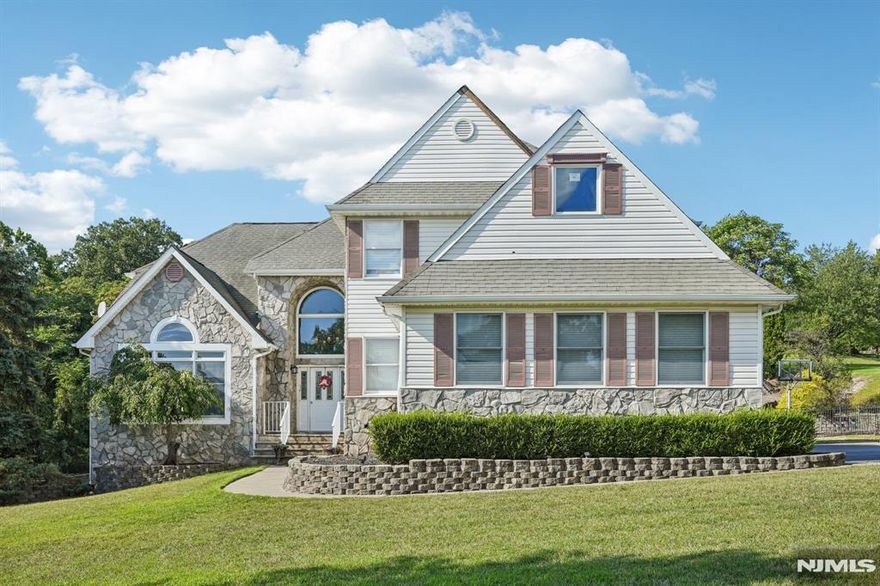 Welcome home to this exquisite 6 bedroom, 5.5 bathroom Colonial, situated on a beautifully manicured lot in the prestigious Cobblestone Woods. Step inside the elegant two-story foyer and be greeted by a sun-drenched living room with soaring vaulted ceilings, expansive windows, and gleaming hardwood floors an inviting space for relaxation and conversation. The open flow continues into the formal dining room, ideal for intimate gatherings or festive entertaining. The heart of the home is the chef's kitchen, showcasing custom cabinetry, marble countertops, premium stainless steel appliances, a center island, and breakfast area. French doors open to an expansive deck, offering the ultimate setting for al fresco dining, grilling, and outdoor entertaining. Unwind in the sophisticated family room with its cozy fireplace and seamless connection to the kitchen. Half bath and laundry complete the level. Upstairs, the luxurious primary suite boasts walk-in closet and spa-inspired en suite, while four additional bedrooms and three bathrooms provide comfort and privacy. The full finished walkout basement offers versatility with a bedroom, full bath, second kitchen, den, and access to the backyard. Step outside to your private retreat featuring a sparkling in-ground pool, patio, and lush yard perfect for play or gardening. A three-car garage and ample parking complete this remarkable property. Experience private luxury living just minutes from NYC transportation, shopping, and fine dining.