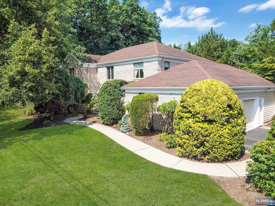 Located on a cul-de-sac, this spacious colonial is designed inside and out for easy entertaining The welcoming foyer seamlessly opens to all living spaces, incl the spacious living room & family room with fireplace, wet bar and access to fenced back yard with patio. The well-equipped kitchen includes a large eat-in area surrounded by windows, creating a bright and airy space that opens to the banquet-sized dining room. The first floor en-suite BR or office is conveniently located near the mud room area that leads to the 2 car garage. Four roomy bedrooms upstairs include the sizable primary suite with lux bath with double vanity, tiled shower, soaking tub and large closets. Downstairs offers a full wet bar, office nook and plenty of storage. Freshly painted exterior, refinished gleaming hardwood floors on two levels, updated baths, newer appliances, & more. Ideally located to blue-ribbon schools, town pool, library, local shopping and dining, and easy NYC commute. Move-in ready