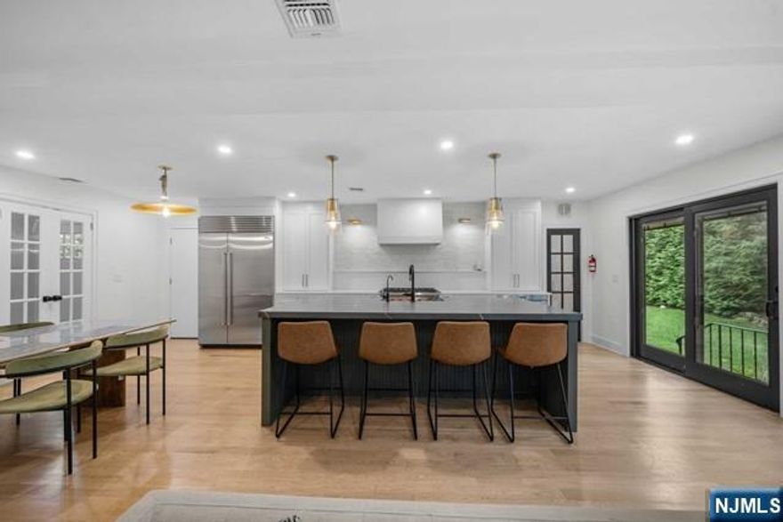 Impeccably renovated colonial on Ridgewood's West Side! Offering the best modern luxury paired with a prime location just a block from Ridge Elementary, the bus and train to NYC, shops, and restaurants. On the first level is an open floor plan featuring a gourmet eat-in kitchen with a trendy oversized center island, Wolf appliances & quartz countertops, overlooking a family room with fireplace, a formal dining room with wet bar, and two convenient 1st-floor bedrooms or home offices/dens that share a stunning full bath. Three bedrooms, 2 full baths, and laundry on the 2nd level, including an expanded primary suite with double walk-in closets and a spa-like bath with cathedral ceilings. Part-finished basement, private backyard with a patio for outdoor entertaining, and attached one-car garage off the mudroom. Enjoy the convenience of being close to everything in this pristine Old Country Club residence!