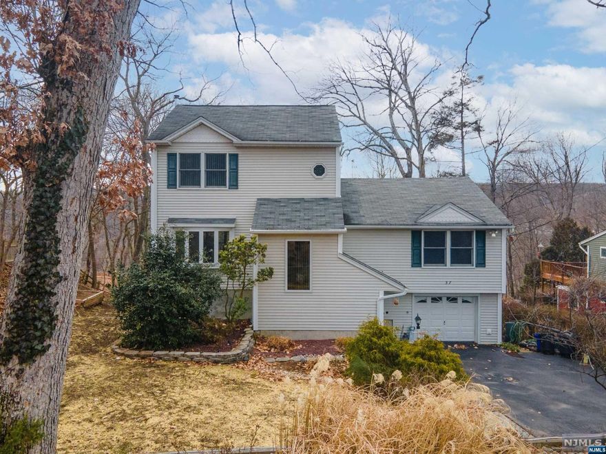 See true pride of ownership at this ideally located 1877 sq ft home. Much larger than it appears, this home is a gem with impressive features and attention to detail. Saunter into the tiled foyer that opens to the oversized entertainment room with wood stove, full bath, utility/laundry room along with a bonus room/office that opens to the tiered scenic, tranquil backyard with paver patio and firepit. The main level with hardwood floored living room and dining room opens to the oversized deck that overlooks the beautiful Ramapo Mountains. The gourmet style kitchen boasts custom cabinets, tiled floors and backsplash along with granite tops. The oversized bathroom is a Jack & Jill off the large-sized bedroom, that can double as a master, along with another bedroom. The upper level features a master bedroom suite with two walk-in closets and a luxurious master bath. Don't miss your chance to own this beautiful, spacious home and be part of Oakland, a silver level sustainability town!