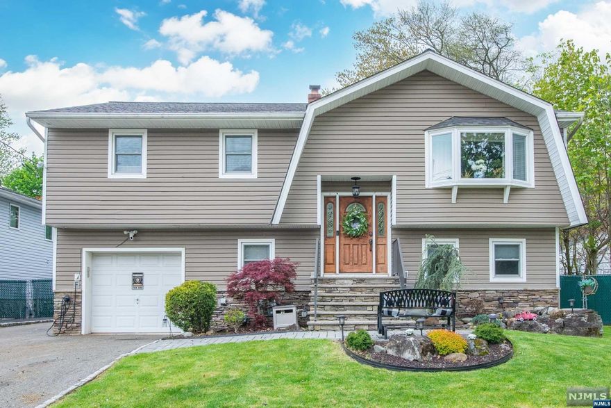 The house you've been searching for! Beautifully RENOVATED bi-level with over 1,800 sq feet set in a quiet neighborhood with 4 bedrooms, 2 baths plenty of entertaining space, a fenced in yard & an above ground pool. 1st floor features 3 bedrooms, 1 newly redone bathroom, an open concept layout with a living room with a HUGE bay window, a renovated kitchen with farmhouse sink, stainless steel appliances, quartz countertops and breakfast bar open to the formal dining room. Sliders leading to the outdoor oasis! Newly redone covered deck with composite decking and railings. Lower level features a family room with custom built ins, wood burning stove, 1 large bedroom, 1 bathroom, laundry room and attached garage with EV charger. Covered patio perfect for grilling and enjoying your backyard with inground pool and completely fenced in! .05 from NYC transportation, steps from shops, restaurants, brewery and more!