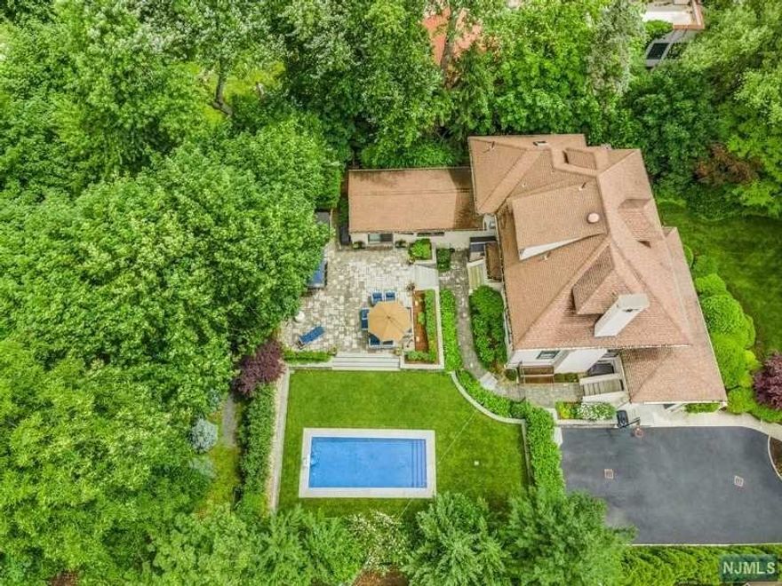 Set high above a sweeping yard on one of Montclair's most coveted streets, 42 Highland offers gorgeous grounds w extensive patio w media hook-ups, views & privacy. Large-scale rooms w high ceilings make living comfortable. There's a grand foyer entrance or enter through a mudroom w a powder room. The kitchen is expansive w plenty of storage, & opens to the extra-large family room w outdoor access. The family room flows onto the vast patio w an outdoor tv, bbq cooking, fire pit, pool & hot tub. The rear yard is fully fenced for security & privacy. Recent improvements include a major restructuring of the rear property drainage, hardscaping & terracing, the addition of the in-ground pool, hot tub, & expansion of the driveway & patio. Spacious bedrooms & several office spaces on the upper floors. The primary bedroom is extra large. The basement is finished w entertainment/play area, gym, powder room, laundry, storage, mechanical room, & workroom w workbench.