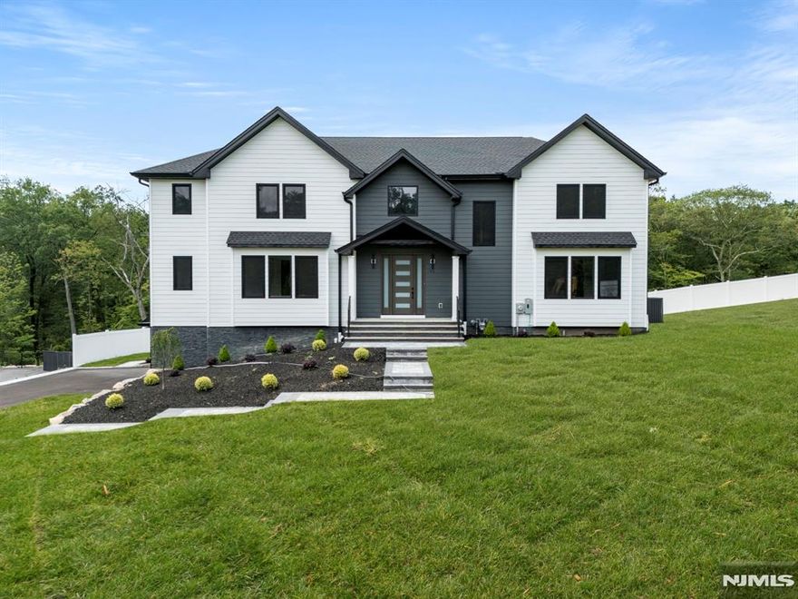 NEW: Builder Incentives Now Available! Brand new 2025 Colonial-style home offering nearly 4,000 sq. ft. of sophisticated living space, thoughtfully designed for comfort, style, and modern functionality. This 5-bedroom, 4.5-bath residence includes a dedicated home office, finished walk-out basement, and 3-car garage, all nestled in a peaceful Northern New Jersey setting surrounded by nature. Inside, you'll find engineered wood flooring, recessed lighting, and elegant millwork throughout. The airy two-story foyer sets the tone, leading to bright, open-concept living and dining areas. A butler's pantry with a wine cooler connects to the kitchen, which is equipped with quartz countertops, matte black steel appliances, a farmhouse sink, exhaust hood, and a generous center island. The family room features an electric fireplace and large windows overlooking a fenced, landscaped backyard with a deck ideal for indoor-outdoor living. Upstairs, the primary suite impresses with a walk-in closet, freestanding soaking tub, dual vanity, and oversized shower. Four additional bedrooms, two full baths, and a full laundry room complete the second level. Added features include European triple-pane windows, central vacuum system, and a New Home Warranty for added confidence. A versatile finished basement with full bath and outdoor access adds valuable living space. Move-in ready and built to the highest standards. This home checks every box!