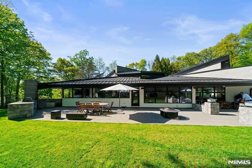Seeking the ultimate in secluded privacy only minutes from Manhattan? Discover this elegant contemporary home located at the end of a cul-de-sac in one of Cresskill, NJ's most desirable neighborhoods. Set on over two meticulously landscaped and forested acres in the most private of settings, this recently renovated home features soaring ceilings and expansive windows that seamlessly blend indoor and outdoor living spaces. Enjoy the immense bluestone entertainment area with outdoor kitchen, or unwind in the heated in-ground pool nestled in a secluded blue stone courtyard. Relax with a glass of wine from your temperature-controlled wine cellar, watch a movie in your high-end home theater or relax and enjoy your favorite music through the built-in Nain/B&O audio system. Then retire to the primary suite with its lofty cedar ceilings and white oak floors, and enjoy the peace of your spa-like primary bath. VIRTUAL TOUR gives access to property website for additional information.