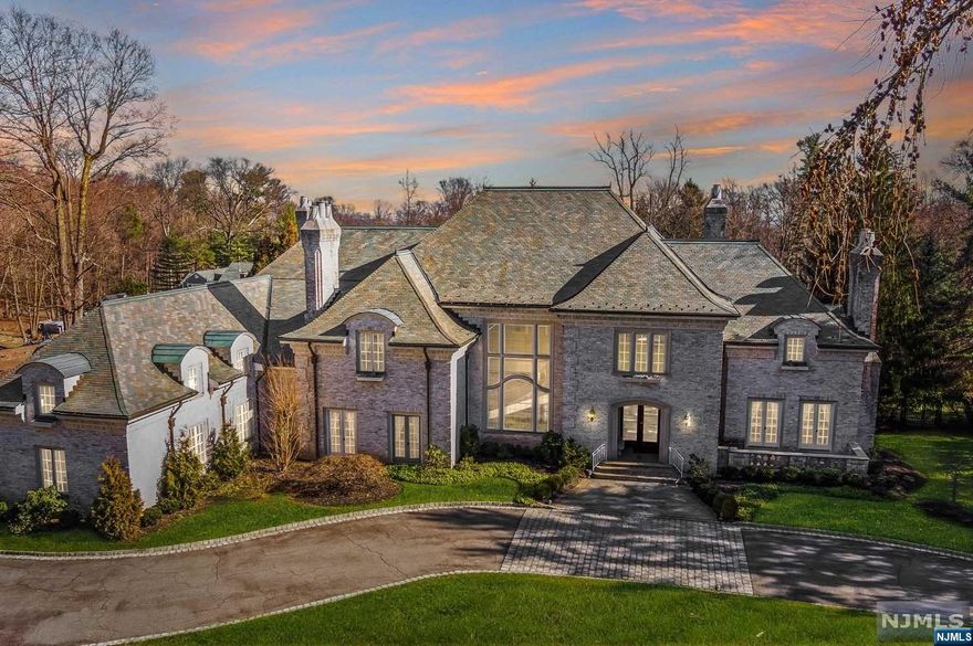 Nestled within the esteemed gates of Llewellyn Park, 14 miles from the vibrant heart of NYC, this French country-inspired estate stands as a masterpiece of timeless elegance. Every detail, from the opulent marble floors to the ethereal hand-blown glass fixtures & the majestic onyx columns adorning the dining room entrance, speaks of unparalleled craftsmanship & architectural grace. With 6 beds, 6 full baths & 3 half baths, it boasts a wealth of space & amenities. An elevator ensures effortless access to every level, while the 3-car garage exemplifies convenience & security. The primary suite on the 2nd level is a haven of opulence. It features a private sitting room graced by a comforting fireplace & a well-appointed wet bar. Flanking this sanctuary are 2 luxurious marbled bathrooms & expansive walk-in closets. On the lower level, the in-law suite, complete with a private entrance, caters to guests with grace & privacy.