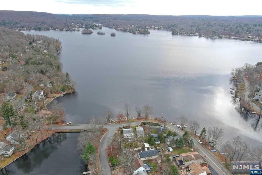 Diamond in the rough! This is a great opportunity to own in the Island Section of upper Greenwood Lake community. Two bedroom ranch home, directly across from the lake, has so much charm. A great condo alternative. Backyard has a custom dog enclosure with roof. Front enclosed porch with view of lake, rear deck also features view of lake. Large driveway. $235 yearly lake fee. Furnace 2016 and bath redone 10 years ago. This community offers a beautiful lake, beach and clubhouse. Not far from Warwick, restaurants and much more. House is strictly as is. Buyer responsible for smoke CERT. Fireplace has been removed. Also all contents to be removed by buyer. Please note: this home is sold "AS IS". Buyer will need to submit an application to the dock committee.