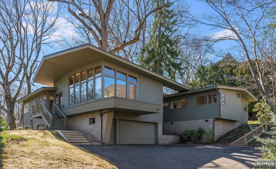 The original owner of this Mid-Century Masterpiece, located in the heart of the exclusive Northside of Summit, used his own lumber company to pick the rarest of woods, the finest craftsmanship available and the highest custom detailing of its kind to mimic an original Frank Lloyd Wright bespoke home. This circa 1950s home boasts 12 rooms, 6 bedrooms, and 3.2 sparkling baths to match the glistening Chef's kitchen. Enjoy the NYC views as you enjoy the endless entertainment spaces which lead out to multiple terraces and almost an acre of mature grounds. Speaking of entertaining, this quintessential "Mad Man" home comes with a hidden martini bar, cove lighting, & a California wall of glass that brings the outside in! Perfect for a Samba Line or dancing to the crooning voices of the Rat Pack. Included in the sale of this home is the property at 36 Glendale Road, a 54 x 150 empty lot. Come live the life of the 50s but enjoy all the amenities of this decade with plenty of outdoor space