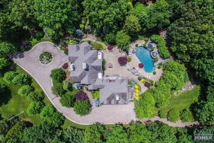 This Majestic Mountainside Estate is exquisitely appointed w/hand-cut natural stone nestled atop a ridge on 4+ Private Manicured Acres w/breathtaking Sunsets & River/Mtn Views. A Masonry Masterpiece built to withstand the test of time is detailed w/granite, fieldstone & bluestone. This 7240sf Magnificent Manor offers the finest amenities, appliances, moldings, masonry craftsmanship & architectural finishings. Designed for Year Round Entertaining, this truly remarkable Lifestyle Home is characterized by its Outstanding Outdoor Hardscape featuring: multi-level Stone Patios, one of a kind 13' deep heated/lighted Resort-Like Pool w/dramatic Waterfall/Grotto/Spa, Outdoor Cafe w/Wet Bar, fabulous Fireplace, separate Fire Pit & professional grade Viking Cooking Station. The property overlooks 1000's of acres of Wooded Parkland all for your hiking pleasure. Bring all your toys and store them in the private Riverside Recreation Center. Top Rated School District.
