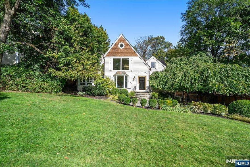 Welcome to 70 Llewellyn Road, an elegant retreat on one of Montclair's most coveted streets. This custom residence blends sophistication and comfort, offering privacy and tranquility just moments from downtown shops, dining, parks, and NYC transportation. Step inside to discover beautifully designed living spaces perfect for entertaining or everyday living. The first floor unfolds with a gracious living room featuring recessed lighting and a wood-burning fireplace, opening to a sunlit sitting area that invites relaxation. The expansive family room flows into a chef's kitchen with stainless steel appliances, Thermador gas range, center island, two dishwashers, wet bar, and wine fridge all overlooking a private patio ideal for gatherings. A formal dining room, large office, and first-floor bedroom suite with a private bath complete this level with elegance and versatility. Upstairs, the serene primary suite offers a luxurious escape with a skylight, sitting area, walk-in closet, and spa-like bath with soaking bubble tub and glass-enclosed shower. Three additional bedrooms, a full bath, laundry, and a cozy landing with custom built-ins complete the upper level. The finished walk-out basement includes a recreation room, mudroom, powder room, laundry, and direct garage access. Outside, enjoy a deep backyard with privacy fencing, expansive paver patio, and wide driveway for guests. Move right in and experience Montclair living at its finest.