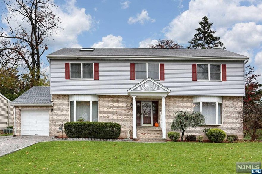 Picture perfect center hall colonial! Situated on a terrific cul de sac in Dumont's 'White Beeches' section! Built in 1988 boasting approx 2579 sq ft this well cared for home features entry foyer, large living room with fireplace opens to wonderful sunlit Florida room with access to large deck and private rear yard. Formal dining room. Stunning newly updated kitchen with peninsula, separate eating area, custom cabinetry, stainless steel appliances, granite counter tops, and dual dishwashers! Off the kitchen is a convenient laundry room/mud room with access to deck and garage. 1st floor powder room. Upstairs master bedroom suite with vaulted ceiling/skylight, expansive dressing room and master bath! Three more good size bedrooms and 2nd full bath. Beautifully finished basement rec room with high ceilings. Gleaming hardwood floors throughout, four zone gas hot water baseboard heat, central air conditioning, maintenance free brick and vinyl siding. One of the best homes in town!