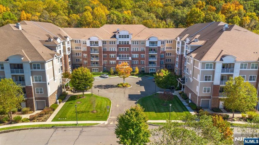 This impressive penthouse in Wanaque Reserve, a Del Webb active adult 55+ community, is a 2,767 SF home with 3 bedrooms (one used as a sitting room), 3 full baths, a gourmet eat-in-kitchen with cherry cabinets, granite counters, stainless steel appliances & center island, formal dining room, great room, den, and tiled balcony with beautiful wood views. This rare unit includes upgraded features, two deeded parking spots, a 6x10 deeded storage unit, two entrances, and a flexible separate space with the 3rd bedroom and full bath, ideal for guests or family members. Residents have access to a 20,000 SF clubhouse with a cafe, indoor and outdoor pools, gym, theater, tennis and pickleball courts and over 45 clubs and activities. Children 19+ can live in the community. The home is located in the more scenic part of the community...in the newest building. This home is a must-see!