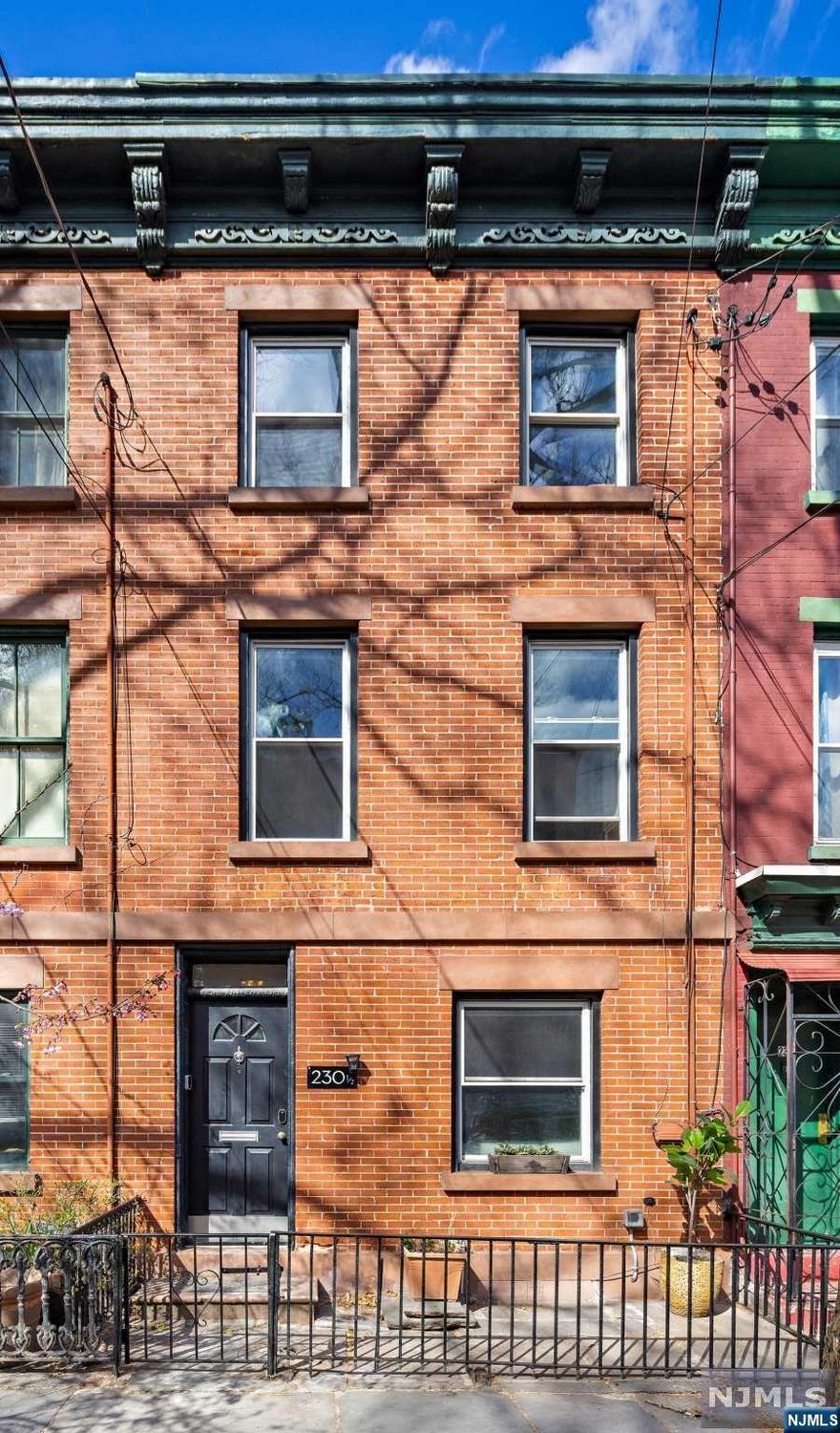 Come and see this historic three-story brick townhome with restored brick facade. You're welcomed by an open-concept living, kitchen, and dining area with a new white concrete fireplace. The kitchen features quartz countertops, SS appliances and offers seamless access to the courtyard and backyard garden. Ascend the staircase guided by a curved mahogany banister where you'll see a living space enhanced with original marble mantle, updated hardwood floors and the first of three bedrooms. The third floor includes two bedrooms with spacious closets. Relax in the iconic claw foot tub or enjoy the renovated standing shower that blends modern and rustic feel with its exposed bricks and beams giving you the best of both worlds. This home also features a full-unfinished basement, 3 level split A/C system with smart controls and an external 240 outlet for emergency EV charging. This home is located in JC, Downtown and Harsimus Cove that offers dining, shopping and transportation to NYC.