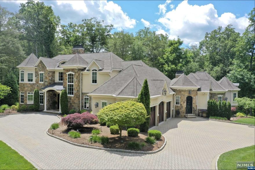 Secluded sanctuary at end of tranquil cul-de-sac in desirable Chestnut Ridge section of Saddle River, this custom built home features a large artisan crafted kitchen, elegant upgraded finishes and woodworking throughout the entire home. 1st floor includes both an owner's suite and a large extended family suite, with summer kitchen, living room & separate entry making it a perfect fit for extended family or guests. Spectacularly finished lower level with 2 outside rear entries boasts oversized gym, bar room, pool table area, a room ideal for home schooling, craft-room, or working remotely, and so much more, adding 3,750 sf of finished living space to total nearly 10,000 sf! The very private 2.3-acre park-like setting offers an expanded multi level patio with gas fire pit, along with a covered outdoor kitchen with TV and gas fireplace. Natural gas generator, lush mature landscaping along with picture perfect views make this a one-of-a-kind offering!! Approved for pool...