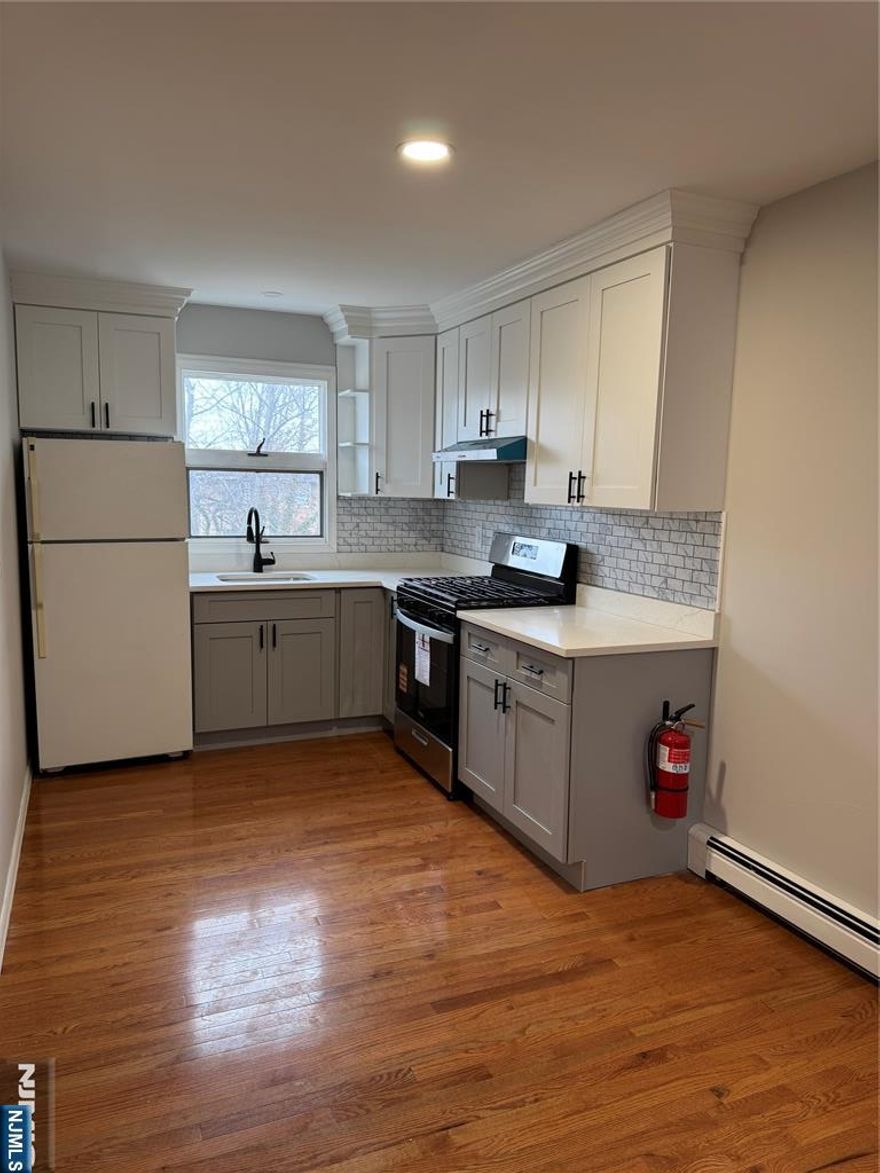 Well-maintained and updated 2 bedroom, 1 full bathroom apartment located in desirable East Rutherford. The unit offers a spacious primary bedroom featuring a sitting area and walk in closet, providing excellent flexibility and comfort. Enjoy an open kitchen and dining area and a large upstairs living room. Additional features include private basement laundry hookups, shared use of the backyard, two off street parking spaces, and separate utilities. Just 3 blocks from Rutherford's train and bus station and minutes to major highways, this location is a commuter's dream with easy access to NYC. Close to shopping, dining, and local amenities.