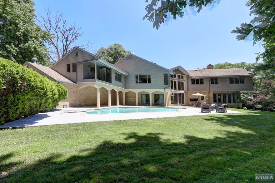 This Stunning custom-built 5 BR, 5.5 bath contemporary home has a spacious and tasteful aesthetic. Approximately 7000 sq ft of living space, an in-ground swimming pool, and a sprawling 8 car garage is spread over an acre of land in a quiet cul-de-sac with only 9 homes on the block. Immaculately maintained by the original owners, the 1st Fl features a grand entry foyer, carved double doors, FLR leads to a FDR and sun filled EIK. The stunning great room with floor to ceiling stone FP, glass windows and French doors leading to the patio. Kitchen w huge CI, with plenty of storage, fully functional appliances, double cooktops & more. The guest bedroom can also be used as a home office and has a separate entrance door. On to the 2nd level, the palatial Master suite offers his and hers bathrooms and closets, open loft with a FP. 3 more BR & 2 bathrooms. Massive unfinished basement w huge potential to be finished. Close to Rt 208 & 20 miles from NYC. 2nd lowest tax rate in Bergen County.