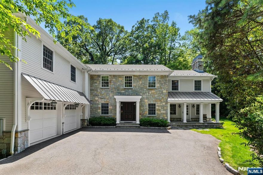 Where classic design meets modern comfort on the East Hill. Hamptons-style 5BD, 5.1BA Col. sits on 25k+ SF of manicured property. A stone & HardiePlank ext w/covered porch welcomes you to a radiant-heated 2-story entry w/rich HW flrs & custom millwork. The LR fts a FPL & coffered ceilings, while the DR includes detailed trimwork. Beautifully designed EIK ft Sub-Zero, 6-burner range, dbl ovens, warming drawer & 2 dishwashers. A walk-through butlers pantry fts wine cooler. Spacious mudrm w/ample storage & PR leads to a 2-car garage. The FR boasts gas FPL, coffered ceilings, built-ins & access to outside. Upstairs, 4 oversized ensuite BDs await. The primary suite is a luxe retreat, w/WIC, dressing area, vanity & spa-like BA ft tub, steam shower, radiant flrs & dbl vanity. Fin LL ft. rec area, 5th BD, full BA, office, storage & ext. access. Private backyard fts stone patio w/outdoor FPL, perfect for al fresco dining. Minutes to Tenaflys schools, downtown & NYC commute.
