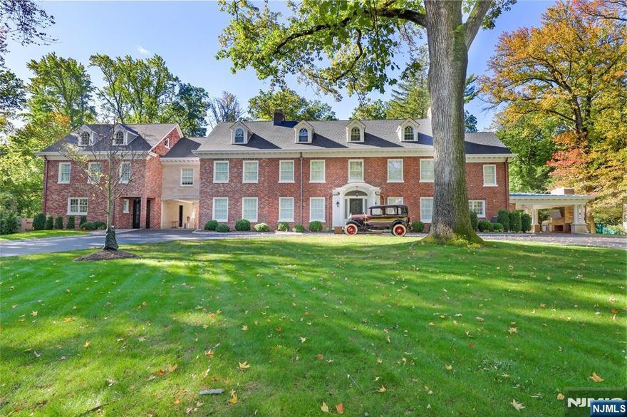 An extraordinary red-brick and stone colonial estate awaits on 2.13 pristine park-like acres, representing a century of architectural heritage reimagined for contemporary luxury living. This remarkable 15,000-square-foot residence combines historic grandeur with cutting-edge modern amenities, featuring two fully separable living quarters connected by elevator across four floors. Eight family bedrooms, three guest rooms, nine full bathrooms and three half bathrooms, and two chef's kitchens create an unparalleled experience. Complete 2022-2023 renovation honors original 1915 details while incorporating state-of-the-art systems. Saltwater pool, pool house, three-car garage, and standby generator provide luxury living just three miles from Manhattan.