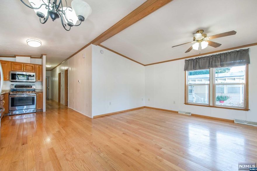 Presenting the epitome of homeownership pride! This meticulously crafted manufactured home, constructed in 2004 without compromise, harmoniously blends modern living, affordability, and functionality. The allure begins with a recently added side deck in 2020 and an inviting front porch. Included are two dedicated parking spaces right in front, plus extra street parking options just across the way. As you step inside through the top-quality storm door, you'll be greeted by high ceilings and exquisite hardwood floors throughout. The open-concept design offers flexibility in arranging the interior to suit your taste. Your purchase comes complete with a full suite of stainless steel appliances, including a refrigerator, microwave oven, gas range, washer, and dryer. Adjacent to the dining room, brand-new sliding doors grant effortless access to the side deck. The embodiment of pride in homeownership, seamlessly combining contemporary comfort with budget-friendly living.