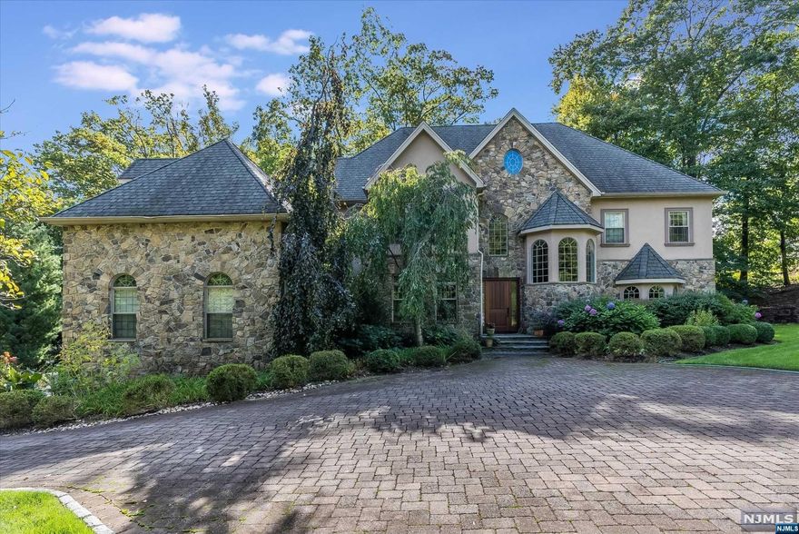 Tranquility abounds in this lovely leafy green private estate! 272 Valley Way sits in a serene setting overlooking a stunning gunite saltwater pool and cozy hot tub w/ an impressive stone deck perfect for entertaining. Perched in the coveted Estate Section of Montclair, this 22-year-old home has everything for today's discerning buyer. A delightful foyer welcomes you into a warm, inviting home that leads to a spacious family room with wood-burning fireplace overlooking a private deck. The 1st-floor flow has a private office, a charming sitting room, & a formal dining room with a separate butler's pantry. The heart of the home is the spacious chef's kitchen, with high-end appliances, the perfect space to gather & connect to the outdoors. On the second floor, the gracious primary suite has large windows, 2large walk-in closets,wet bar,& spa-like bath.3 more spacious bedrooms all with hardwood floors and en suite baths round out the 2nd fl. Bonus working elevator serves all 4 floors.