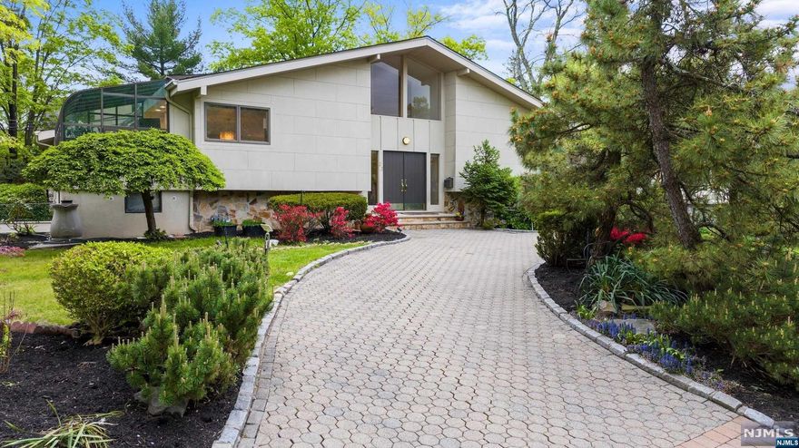 Welcome to contemporary luxury in Englewood Cliffs sought-after North Cliffs! This renovated home offers 4 Bedrooms and 3 Full Baths and blends modern aesthetics w functional elegance. Step inside to discover a sleek open concept with mid-century modern vibes and stylish wood-paneled accent walls. The centerpiece is the custom kitchen w Sub-Zero fridge, Miele appliances, quartz countertops, and a stunning center island. Flowing from the kitchen is a bright sunroom for dining or relaxing. First floor features a spacious living rm open to family rm w fireplace & soaring ceilings. 3 bedrooms and 2 full baths complete this floor. Oak engineered wood floors w radiant heat throughout comfort the entire first floor. Lower level offers more living space with a bedroom, full bath, office area & recreation rm w summer kitchen, opening to a sundrenched patio & backyard. Thoughtful design maximizes open flow and functionality. All renovations completed 4 years ago, this home is move-in ready!