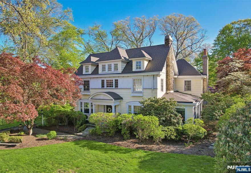 Exceptional Center Hall Colonial in Ridgewood's prestigious Old Country Club section, masterfully blending classic architectural integrity with a sophisticated, modern aesthetic. Set on a sprawling 0.7-acre level lot, the residence underwent extensive upgrades that elevated its traditional charm into a turn-key sanctuary for today's contemporary buyer. The expansive, completely level, backyard is the ultimate retreat with a bluestone patio and a pergola that serves as an outdoor lounge with a full kitchen, fireplace, and dedicated TV nook. The interior is defined by an airy, light-filled layout complemented by hardwood floors, 4 fireplaces, and exquisite ceiling details. At the focal point of the home is a gourmet kitchen boasting honed Calacatta Gold marble, a striking walnut butcher-block island, and a counter-height hearth. A spectacular great room flows seamlessly from the kitchen, both with radiant heated floors, offering a 10' coffered ceiling, cast stone fireplace, and elegant French doors. Wrapping up the main level are banquet-sized dining and living rooms, a private office, mudroom, and powder room. Upstairs, the large primary suite includes a tray ceiling, a private balcony, and a spa-like bath with a steam shower and radiant heat. Upper levels include 6 generous bedrooms total, while the finished basement offers versatile rec space. Located near top schools and transportation to NYC, this property is a rare fusion of historic craftsmanship and current-day luxury!