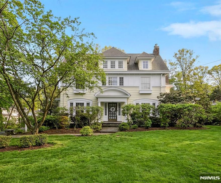 Exceptional Center Hall Colonial in Ridgewood's prestigious Old Country Club section, masterfully blending classic architectural integrity with a sophisticated, modern aesthetic. Set on a sprawling 0.7-acre level lot, the residence underwent extensive upgrades that elevated its traditional charm into a turn-key sanctuary for today's contemporary buyer. The expansive, completely level, backyard is the ultimate retreat with a bluestone patio and a pergola that serves as an outdoor lounge with a full kitchen, fireplace, and dedicated TV nook. The interior is defined by an airy, light-filled layout complemented by hardwood floors, 4 fireplaces, and exquisite ceiling details. At the focal point of the home is a gourmet kitchen boasting honed Calacatta Gold marble, a striking walnut butcher-block island, and a counter-height hearth. A spectacular great room flows seamlessly from the kitchen, both with radiant heated floors, offering a 10' coffered ceiling, cast stone fireplace, and elegant French doors. Wrapping up the main level are banquet-sized dining and living rooms, a private office, mudroom, and powder room. Upstairs, the large primary suite includes a tray ceiling, a private balcony, and a spa-like bath with a steam shower and radiant heat. Upper levels include 6 generous bedrooms total, while the finished basement offers versatile rec space. Located near top schools and transportation to NYC, this property is a rare fusion of historic craftsmanship and current-day luxury!