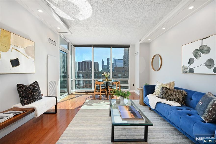 Step into this beautifully designed south-facing home, where floor-to-ceiling windows bathe the interiors in natural light. The gourmet kitchen has been thoughtfully redesigned into an open-concept layout, enhancing both functionality and flow. Featuring premium stainless steel appliances, sleek granite countertops, and a stylish breakfast bar, it is perfect for both entertaining and everyday living. The spacious primary suite offers a serene retreat with an en-suite bath and a well-appointed walk-in closet. Additional highlights include abundant storage, rich hardwood flooring, and the convenience of an in-unit washer and dryer. Residents enjoy an array of top-tier amenities, including a 24/7 concierge, a fully equipped fitness center, a jacuzzi, a sauna, a steam room, a resident lounge, a conference room, a childrenâ€™s playroom, and a breathtaking roof deck with panoramic NYC and river views. Ideally located between the Hoboken and Newport PATH stations, with easy access to the ferry, light rail, Newport Mall, and Newport Green Park, this home offers both luxury and convenience in the heart of it all.