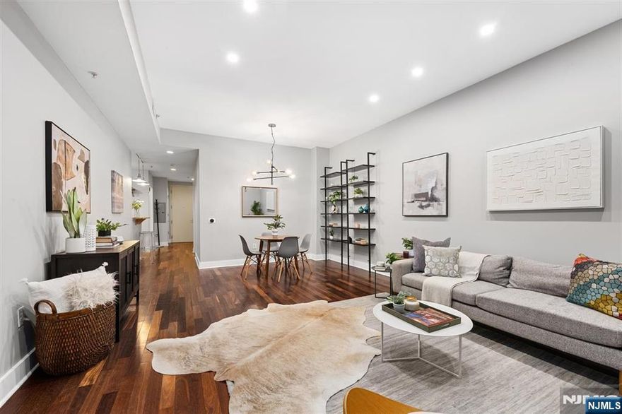 Welcome to Waldo Lofts, an award-winning boutique condominium in the coveted Powerhouse Arts District of Downtown Jersey City. This stylish 1-bedroom, 1-bath home offers approximately 829 sq ft of thoughtfully designed living space, blending modern finishes with a smart, open layout. Highlights include hardwood floors, soaring 10-foot ceilings, central A/C, recessed lighting, and an in-unit washer/dryer. The open living and dining area is framed by dramatic floor-to-ceiling windows, filling the home with natural light. The contemporary kitchen features stainless steel LG appliances, full-height maple cabinetry, granite countertops, mosaic tile backsplash, pendant lighting, and a breakfast bar ideal for entertaining. The spacious bedroom includes a walk-in closet for excellent storage. Residents enjoy premium amenities such as a fitness center, package room, bike storage, and secure key-fob access. The professionally managed building offers an on-site superintendent five days a week and cleaning services six days a week. Recent upgrades include a renovated lobby and advanced video intercom system. Monthly HOA fees cover hot water, gas, and Verizon Fios. Just moments from the Grove Street PATH, this home provides quick access to NYC and places you steps from Downtown Jersey Cityâ€™s vibrant dining, shopping, and cultural scene. Parking available nearby for an additional fee.