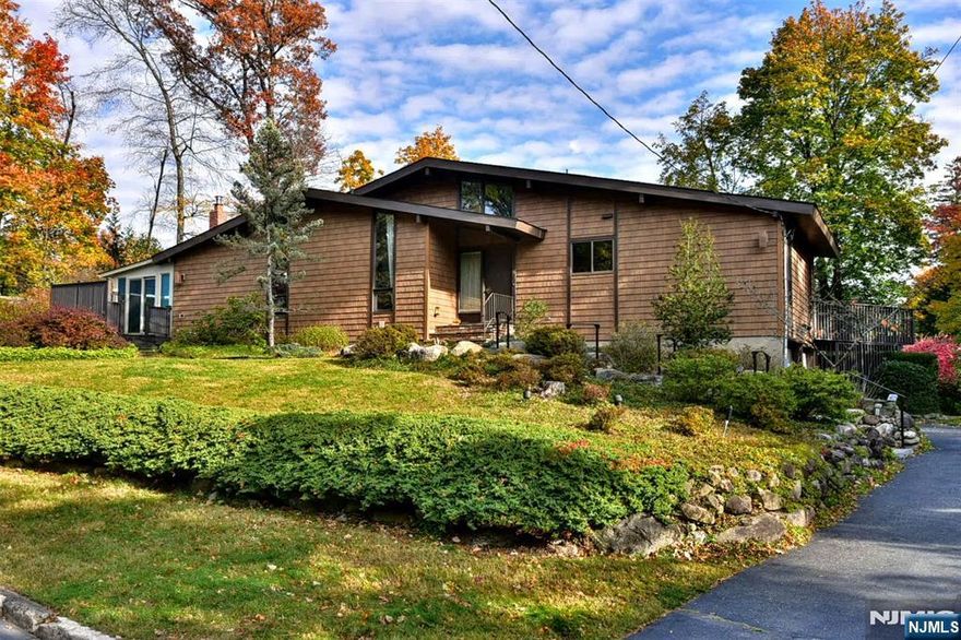 First time available. Original owner. Solid and well loved, this lovingly well maintained home and property, with newer roof and updated siding, offers a rare opportunity to update to your tastes. Enjoy the sight and sounds of nature on this great property on a quiet street in the wonderful town of Park Ridge. The perfect place to unwind in nature after a long day at the office. Spring and Summer offer a bounty of plants and flowers throughout the property. Full finished basement with fireplace and sliding door out to the private back yard. Close to shopping, restaurants, nyc transportation, houses of worship, recreation including town pool & schools. Park Ridge also has it's own water and electric departments.