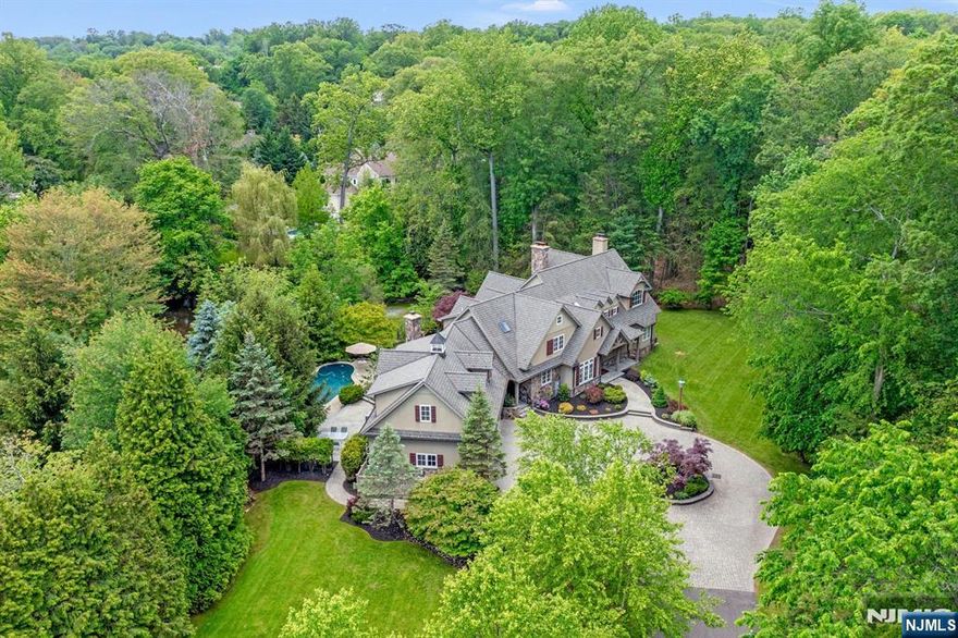 Experience luxury in this custom-built modern European farmhouse, situated on a private 1.6-acre lot with picturesque pond views. This exquisite property boasts a sophisticated gunite pool, blue stone patio, outdoor fireplace, and built-in grillâ€”perfect for entertaining and relaxation. Crafted with premium materials such as masonry stucco, stone, copper gutters, and a robust 40-year roof, the home offers convenience with a 3-car attached garage and circular driveway. The great room is a true centerpiece, featuring a stone wood-burning fireplace and a vaulted ceiling adorned with molding and Swiss-imported reclaimed beams, adding unique character. The high-end kitchen is a culinary dream, equipped with a Sub-Zero refrigerator, custom inset cabinets, and a spacious island. Additionally, the finished basement enhances the living space with a wet bar and a stone fireplace, ideal for entertainment. With 5 bedrooms and 5.5 baths, this residence effortlessly blends modern amenities with timeless charm, designed for those who a ppreciate quality craftsmanship.