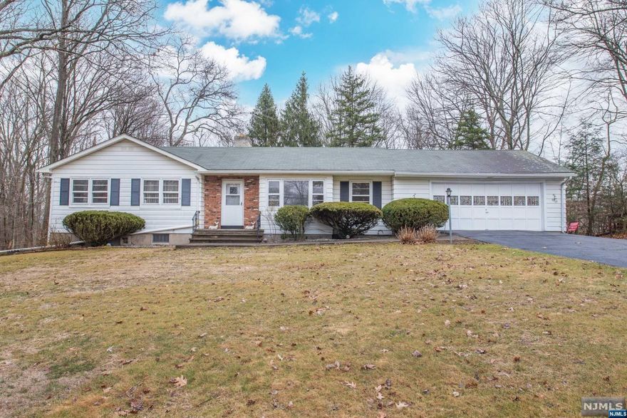 Welcome to this three bedroom ranch (needs updating); set back on large level lot with plenty of curb appeal. Great location for commuters centrally located between highway and town center, close to shopping and outdoor activities throughout the year. Inviting fireplace in kitchen and wood burning stove in basement. Huge driveway can accommodate a dozen cars or more, plus oversized two-car garage and elevator from garage to basement, installed by previous owner. Property is flat and backyard is wooded and private. Large basement can be finished with existing bathroom and convenient walkout to yard.