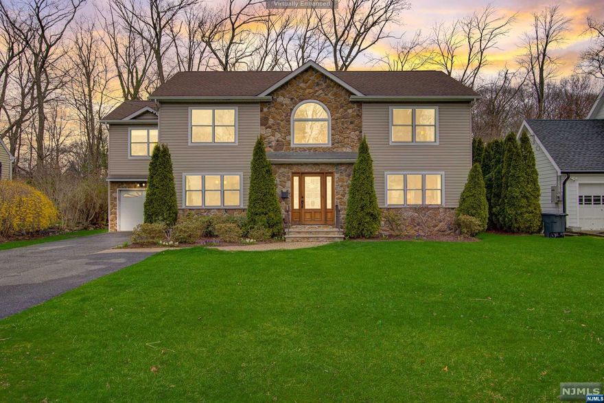 Turn-key Center Hall Colonial built in 2014 just steps from Glen Rock's exceptional Schools, quaint Downtown and NYC Transportation. Luxury two-story Entry with sweeping staircase sets the tone for seamlessly flowing open living spaces. The sunlit Din Rm and Liv Rm span the front of the home and effortlessly transition to a generous Fam Rm with gas Fireplace and a welcoming Kitchen with Center Island seating and Breakfast Area with sliders onto the flat grassed backyard. Powder Rm completes the 1st floor. Ascend to the 2nd Floor to find 4 generous corner Bedrooms and 3 Full Baths. The Primary Suite boasts Walk-In Closet and Luxe Spa Bath with jetted tub and separate stall shower. Junior Ensuite has Full Bath with stall shower. 2 add'l Bedrooms are served by a crisp white Bath with double vanity. Convenient 2nd Floor Laundry. Finished Basement with 1/2 Bath. Double width driveway and attached 1-car garage with convenient access into kitchen. Be prepared to fall in love!