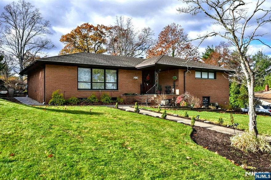 A wonderful opportunity awaits with this beautifully crafted custom brick ranch. Step inside to a warm foyer with flagstone flooring, spacious formal living and dining room, with gleaming hardwood floors throughout. The maple gourmet eat-in-kitchen features newer stainless steel appliances, plenty of room for cooking and entertaining. Relax in a very impressive family room with custom cabinetry, granite countertops, gas fireplace, oak ceiling with skylight and abundant windows that frame backyard views. Two sets of sliding glass doors lead to patio and deck. The main level offers two generous size bedrooms, two full baths, formal living room, dining room, family room, kitchen and a convenient laundry area with built in iron board. The primary suite includes a full bath and large walk in closet. There's so much more to this home than meets the eye. The fully finished lower level offers incredible flexibility, featuring a private entrance with endless possibilities for living space. The layout opportunity includes a large bedroom space, comfortable family room, office, full bath, perfect for guests, or work-from-home needs. Outside, enjoy the private two tiered backyard with Cambridge paver patio, bluestone tile, covered gazebo, gas grill, granite counter top, and refrigerator. Home has oversized 2 car garage. 2 yr old underground sprinkler system, 1 yr old security system. Close to shopping, transportation, NYC. Don't miss out. A must see!