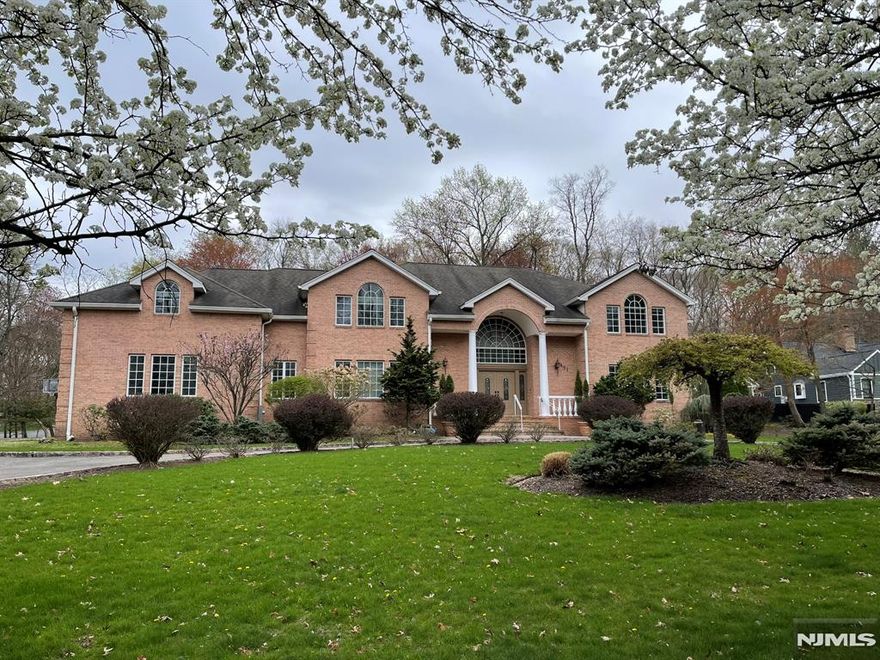 Welcome home! This custom home has room for everyone inside and out. Enter the grounds via the circular drive and are welcomed into the home in the luxurious foyer. A double bridal staircase and crystal chandelier greet you. The home features formal living and dining room. The family room has a soaring ceiling. A custom kitchen is ready for the chef, with stainless appliances. A sun filled breakfast area is perfect for the morning. Ascending the curving staircase to the second floor the hallway bridge overlooks the elegant foyer and family/great room. The second floor features a primary suite, huge closet, spa like bath, office and sun room. Three more bedrooms with en-suite baths complete the second floor. A first-floor bedroom with newer en-suite bath is great for guests. Newer basement: movie theater, wet bar, rec area, wine cellar, bedroom, bath. All nestled on a .97-acre lot with large brick patio, sweeping lawn. Near schools, shopping, major commute routes and NYC train.