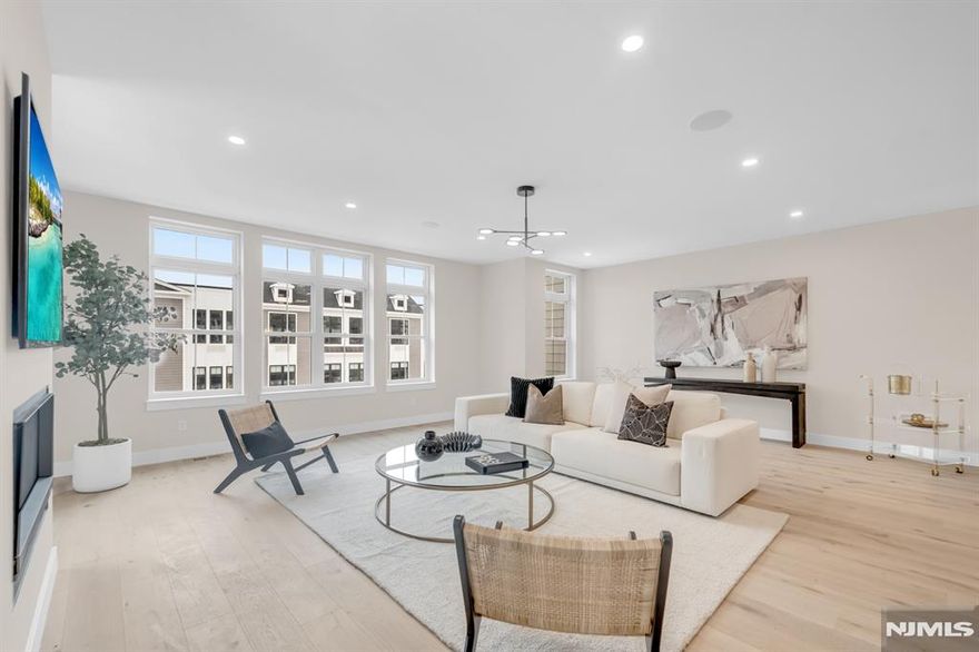 Introducing Lexington on Broadway, a limited collection of just 9 newly constructed townhomes offering refined design, modern comfort, and the added benefit of significant tax savings and incentives! This luxury Corner residence features 3 bedrooms, 2 full bathrooms, 2 half baths, plus a rare to find private elevator to all levels. Attached two car garage, delivering both convenience and low maintenance living in a highly sought after town. Finished with carefully curated high end materials, including Thermador appliances, custom cabinetry, quartz countertops, wide plank oak flooring, and designer details throughout. The ground level offers a finished recreation room with a half bath and access to a covered patio. The main living level is designed for seamless everyday living and entertaining, showcasing an open concept layout with a gas fireplace, wet bar, chefâ€™s kitchen centered around a waterfall quartz island, dining area, powder room, and access to a private deck. The upper level is met by a spacious primary suite with two walk in closets and a spa inspired bath, along with two additional bedrooms, a full bathroom, and a dedicated laundry area. Backing to a wooded setting for rare privacy, the community is ideally located directly across from the commuter train and within a top ranked school district. A 5 year tax abatement offers approx. $75,000 in estimated savings, further enhancing the long term value of this exceptional offering.