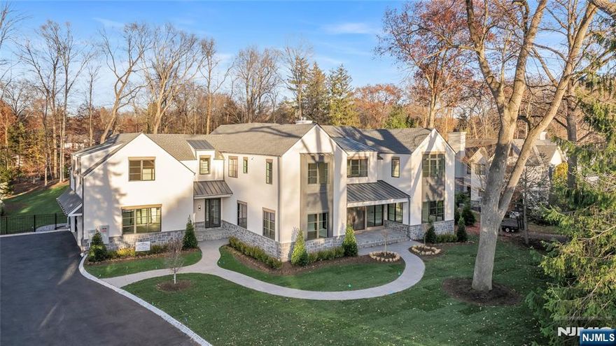 Blending privacy, sophistication, and lifestyle, this 7 BR 7.5 BTH estate sits on a rare private acre and offers 9500+ sq. ft. of custom designed living space. Soaring 10 foot ceilings on the main level and 9 foot ceilings above and below create an airy open feel. The chefs kitchen w/Sub Zero and Wolf appliances, dual dishwashers, oversized island, and bespoke cabinetry flows into a sun filled family room w/ double sided gas FP and wall of glass overlooking the landscaped property. A floating wine display defines the transition between the dining and LR, while the DR wet bar enhances effortless entertaining. A main level suite w/ radiant heated bath offers an ideal guest haven, and a first floor office provides elegant work from home space.Upstairs, five ensuite BR feature radiant heated baths. The primary suite is a serene retreat, showcasing a vaulted ceiling w/ exposed beam, gas fireplace, spa inspired bath, and custom closet with dual islands. An expansive bonus room offers flexible living, and the LNDRY is conveniently located on this level. The lower level includes a theater, wet bar, recreation area, gym, and additional BR w/ FBTH. Outside, a Gunite heated pool with spa and automatic cover, outdoor KIT, covered terrace w/ fireplace, large bluestone patio, and manicured fenced grounds create a private resort. Additional highlights include smart lighting, built-in speakers, 22kW generator, heated 3-car garage, and a separate storage structure ideal for a future cabana.