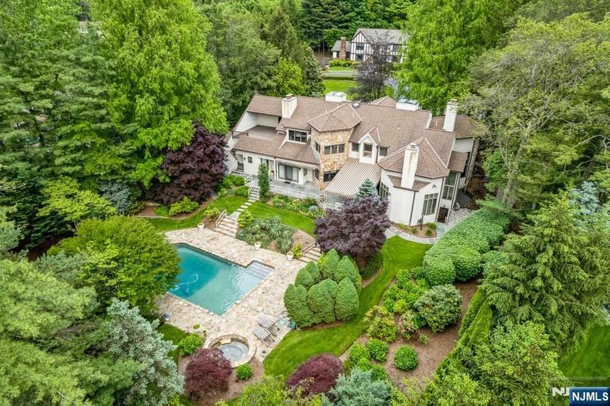 Set on a private corner lot in Cresskill, this spacious Colonial offers mature landscaping, generous square footage, and rare potential to make it your own. The grounds have been lovingly cultivated over decades, providing a level of privacy, serenity, and natural beauty that can't be recreated overnight. Whether you're lounging by the resort-style in-ground pool with diving board, soaking in the hot tub, or enjoying a quiet moment in the garden, the outdoor space feels like a personal retreat - ideal for summer gatherings or peaceful mornings under the trees. Inside, standout features include a 3-car/SUV garage, four wood-burning fireplaces (including one in the primary suite), an eat-in kitchen with center island and breakfast nook, and a dedicated home office with built-in library shelving. The full-height basement - with a full bath and private entrance - offers flexible space for a gym, media room, playroom, or guest quarters. A main-level full bath near the backyard is perfect for post-pool rinse-offs. A first-floor guest suite with private entrance offers comfort and autonomy for extended stays-ideal for multigenerational living. The upstairs primary suite features a fireplace, walk-in closet, bonus room, and a private deck with treetop views - offering a peaceful start or end of each day. Cresskill School District, this home blends timeless character, functional space, and a sense of sanctuary - a home best appreciated in person. EMAIL michael.carlo@elliman.com