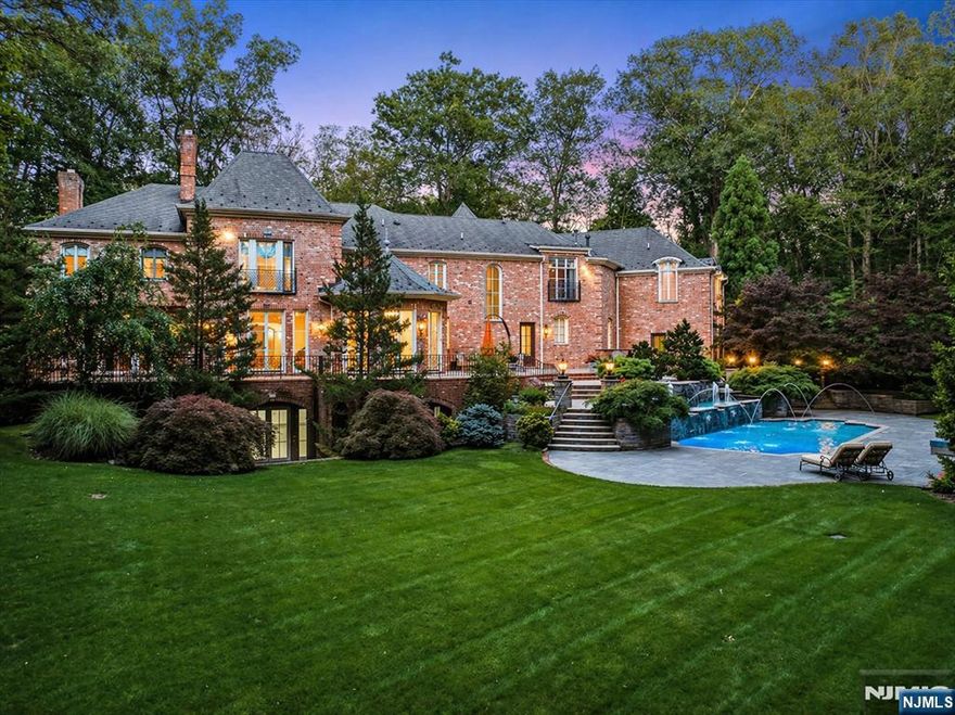 Set behind stately iron gates on one of Saddle Riverâ€™s most coveted streets, this French-inspired estate offers nearly 9,000sf of timeless architecture, privacy, & refined living. Perfectly situated on 2.15 landscaped acres, the home blends grand-scale entertaining with intimate everyday comfort, complete with resort-style amenities. A dramatic two-story foyer opens to sun-drenched formal living & dining rooms, anchored by fireplace & floor-to-ceiling arched windows. A fully appointed butlerâ€™s pantry complements the banquet-sized dining room. Chefâ€™s kitchen features top-tier appliances, oversized island & cathedral-ceiling breakfast area flowing seamlessly into the family room with coffered ceilings & custom built-ins. A rich wood-paneled library w/ fireplace & patio access create the ultimate home office. The 1st floor also offers mudroom, bonus/playroom, full cabana bath & 2 powder rooms. Upstairs, the mezzanine gallery leads to a private primary w/ sitting room, 2 fireplaces, 2 spa-like baths & expansive walk-in closets. The 4 additional bedrooms include 2 ensuites & 2 with Jack & Jill layout. The walk-out lower level features radiant heat, fifth fireplace & space for a theater, gym, wine cellar & guest suite. Outdoors, enjoy a heated saltwater pool w/ spa & fountain, outdoor kitchen & multiple terraces. A heated 4-car garage, radiant heat throughout, generator & advanced security complete this exceptional property with Saddle River taxes, top schools, & easy NYC com