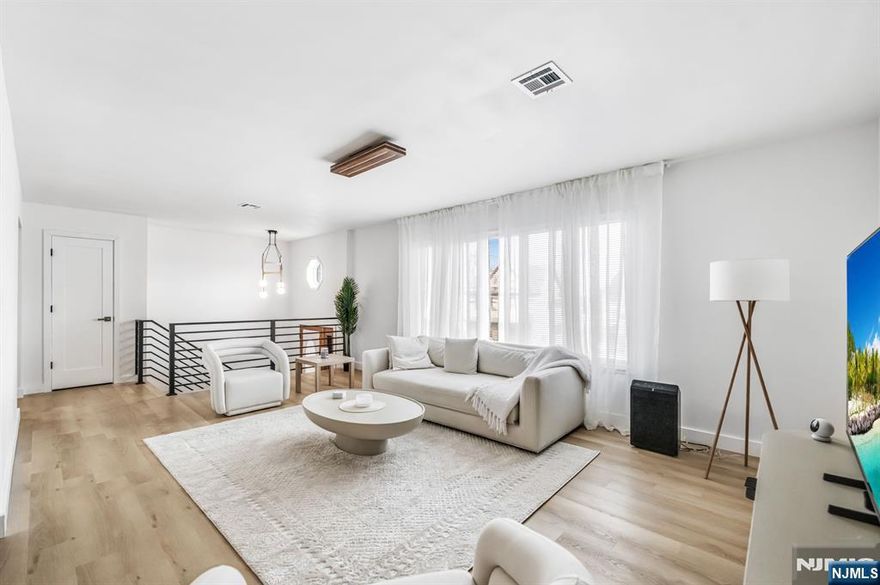 Welcome to this turnkey two-family in Garfield with extensive recent upgrades throughout. This fully refreshed property offers two spacious units and is ideal for an owner-occupant or investor looking for a move-in-ready home with income potential. The upper residence features a spacious 3-bedroom, 2-bath layout designed for comfortable living & effortless entertaining. Sun-filled living spaces with new LVP flooring over Advantech 3/4' subfloor flow seamlessly into the kitchen, now equipped with brand-new appliances and enhanced by clean, modern finishes highlighted by a fully updated bathroom finished with elegant porcelain tile. The primary suite offers a private updated en-suite bath & deck access, creating a comfortable retreat within the home. The second residence offers a well-appointed 2-bedroom, 1-bath layout. The unit provides a generous living space & an updated kitchen featuring all-new appliances. Extensive improvements throughout the home include newly installed air conditioning in both units, recessed lighting, fresh interior paint, & brand-new appliances, creating a crisp & contemporary aesthetic across the entire property. An even bigger bonus- both units have in-unit laundry as well as access to the two-car garage. Ideally located near parks, shopping, schools, and public transportation, this property combines everyday convenience with long-term versatility. This fully upgraded two-family home offers both comfort and opportunity in the heart of Bergen County