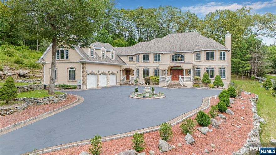 Nestled on over 2 acres at the end of a cul-de-sac, this estate offers mountain and water views along with over 7,000 sq ft of living. A grand two-story foyer with custom flooring sets the tone, leading to a dramatic two-story great room with oversized windows and a gas fireplace, w/ elegant columns. The living room features a gas fireplace, while the dining room boasts exquisite custom woodwork. An arched hallway adds timeless architectural detail. The gourmet eat-in kitchen is equipped with high-end appliances, center island w/ seating, granite countertops, pantry, and French doors opening to a covered patio perfect for entertaining. The 1st floor includes two spacious bedrooms w/ a full bath, a powder room, and laundry room. Upstairs, a balcony overlooks the great room and leads to a luxurious primary suite w/ sitting area, gas fireplace, vaulted ceilings, walk-in closet, and a bathroom featuring duel vanities, jetted tub, and walk-in shower. 3 additional large bedrooms, tray ceilings, 2 full baths, and a bonus room complete the 2nd floor, which also offers a secondary staircase. The lower level, includes a wine room, w/ the potential for additional living space that can be customized. This home is outfitted with 11 zones of heating, radiant heat & 5 zones of A/C ensuring comfort in every room. The home features Nest thermostats & motion-sensor lighting in every room for modern convenience and energy efficiency. Convenient commute to NYC and highways. Truly a rare find!