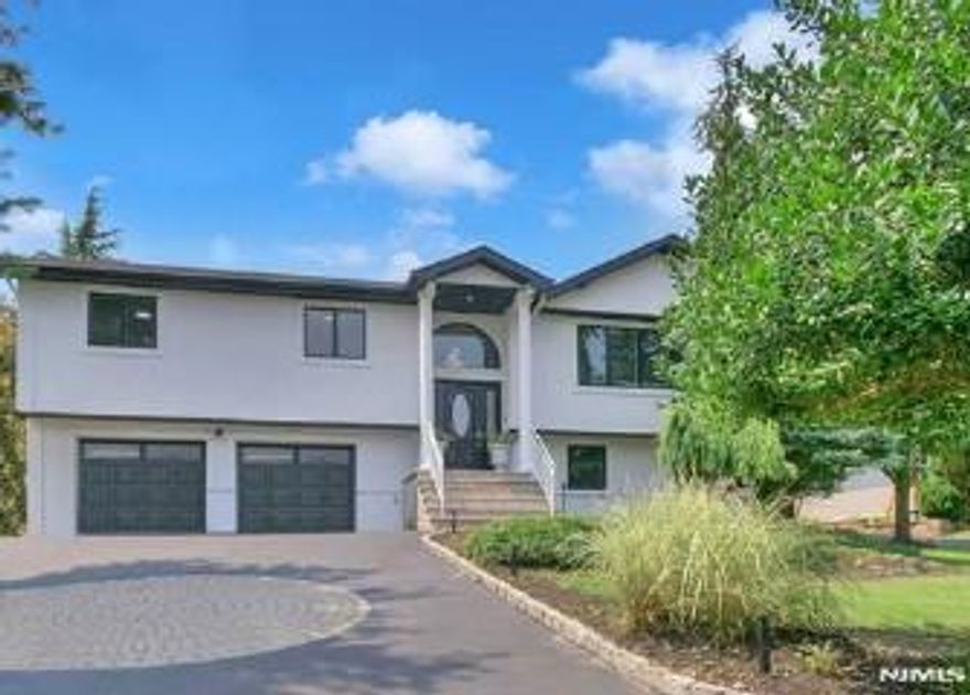 Experience refined living in this stunning contemporary bi-level home, ideally situated in a sought-after Wayne location. Offering 4 bedrooms and 3 full baths, this residence is thoughtfully designed for both everyday comfort and upscale entertaining. The entry foyer leads to an elegant living room highlighted by expansive windows that bathe the space in natural light. A formal dining room seamlessly transitions into a show-stopping kitchen featuring soaring vaulted ceilings, bespoke custom cabinetry, premium stainless steel appliances, a center island, wet bar, and a separate dining area. French doors open to a rear deck overlooking the private backyard oasis. The luxurious primary suite is a true retreat, showcasing a fireplace, walk-in closet, private backyard access, and a spa-like en-suite bath complete with jetted soaking tub, double vanity, and glass-enclosed stall shower. An additional bedroom and full bath complete the main level. The ground level offers an expansive family room with fireplace and custom dry bar, an additional bedroom, and a full bathroomâ€”perfect for guests or extended living. Outdoors, escape to a resort-style backyard featuring an in-ground pool, covered cabana with bar, and a firepit, creating the ultimate setting for relaxation and sophisticated entertaining.