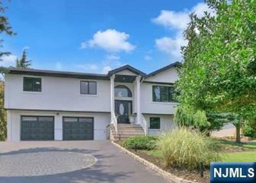 Experience refined living in this stunning contemporary bi-level home, ideally situated in a sought-after Wayne location. Offering 4 bedrooms and 3 full baths, this residence is thoughtfully designed for both everyday comfort and upscale entertaining. The entry foyer leads to an elegant living room highlighted by expansive windows that bathe the space in natural light. A formal dining room seamlessly transitions into a show-stopping kitchen featuring soaring vaulted ceilings, bespoke custom cabinetry, premium stainless steel appliances, a center island, wet bar, and a separate dining area. French doors open to a rear deck overlooking the private backyard oasis. The luxurious primary suite is a true retreat, showcasing a fireplace, walk-in closet, private backyard access, and a spa-like en-suite bath complete with jetted soaking tub, double vanity, and glass-enclosed stall shower. An additional bedroom and full bath complete the main level. The ground level offers an expansive family room with fireplace and custom dry bar, an additional bedroom, and a full bathroomâ€”perfect for guests or extended living. Outdoors, escape to a resort-style backyard featuring an in-ground pool, covered cabana with bar, and a firepit, creating the ultimate setting for relaxation and sophisticated entertaining.