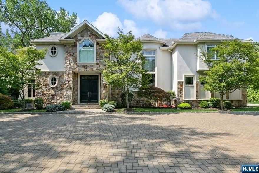 Located atop the eastern hill of Tenafly, on one of the most coveted streets, this luxurious custom colonial home spared no expense. Situated on a sprawling 1-acre property resembling a park, complete w/ pool, it epitomizes elegance. Upon entering, find a formal entryway w/ direct access to living room, while a grand staircase graces the right side. Bar lounge features double-sided gas fireplace connecting to living room. Oversized dining area and modern kitchen opens up to stunning great room w/ gas fireplace. 3-car garage, mudroom, and two half baths complete first floor. Second floor is a sanctuary with a lavish primary bedroom featuring a balcony, gas fireplace, his and her baths, and walk-in closets. There are four more bedrooms, each w/ its own en-suite bath. All the bathrooms and laundry room are equipped w/ heated floors. Walk-out basement is an entertainer's dream, boasting a wine room, theater, rec room, gym, en-suite bedroom, and full cabana bathroom.