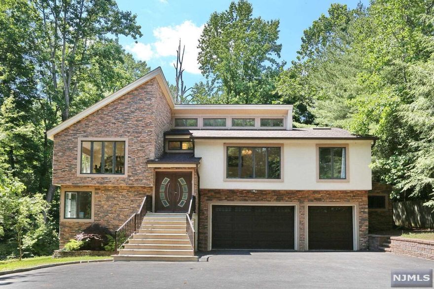 Chic contemporary nestled in a private treehouse setting!! If open concept and privacy are what you are looking for, look no further! Vaulted ceilings, hardwood floors and an abundance of windows overlooking a serene natural setting. Large formal living room with great natural light opens to an equally large family room with fireplace and sliders to the massive deck. Sleek newer kitchen with SS appliances, radiant floors, center island and circular built-in dining table and slider access to new Trex deck. Formal dining room flooded with natural light from the 2 walls of windows! Main level Master ensuite with fireplace, 2 walk-in closets, cherry floors & spa like bathroom. 2nd BR or office, powder room and laundry complete this floor. Expansive grade level features 3 ensuite bedrooms, full hall bath, fabulous game/family room with high ceilings and slider to private wooded rear yard. Don't miss out!!