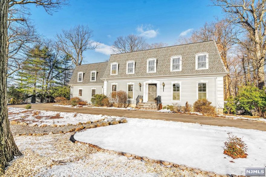 At the top of Englewood's East Hill sits this wonderfully spacious center hall Colonial surrounded by a flat acre of land. As you enter the circular drive it is like visiting a very private part of the French countryside. The grand LR with beamed ceiling, refinished wood floors, FPL and French doors leads to the spacious, new 1100 sqft Trex deck. A large EIK leads to a formal DR, 2 pantries, a 1st flr BDR/FBTH. The PBR has two closets and a new ensuite bath with radiant heat flooring and waterfall shower unit with attached infrared sauna with bluetooth. Laundry room, 3 more BDRS, new FB with radiant heat flooring and steam shower with bluetooth. Surprise! A large movie room with wet bar and built-ins complete this floor. Finished basement has a BR/FBTH, 3rd Lndy RM & private entrance. A patio surrounds the pool anchored by a waterfall and cabana. The Cabana has his & hers dressing rms, FBTH & kitchenette. All this on one of the largest and most private flat lots on Lewelen Cir